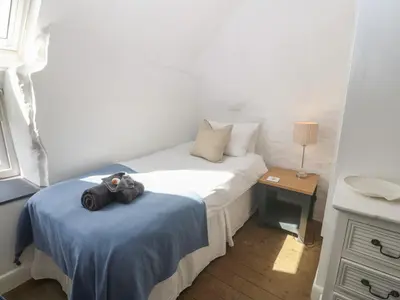 a small bedroom with a teddy bear sitting on a bed at Yr Ysgubor in Dyffryn