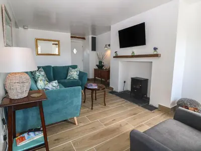 a living room with a blue couch and a fireplace at Yr Ysgubor in Dyffryn