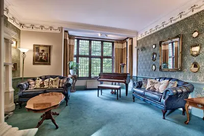 a living room with two couches and a piano at Caer Beris Manor By Group Retreats in Builth Wells