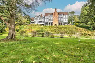 a large house on top of a hill with a tree at Caer Beris Manor By Group Retreats in Builth Wells