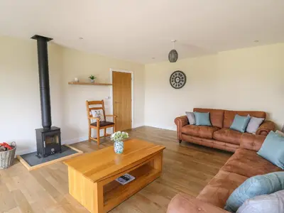 a living room with a couch and a wood stove at Awel y Bryn in Rhayader