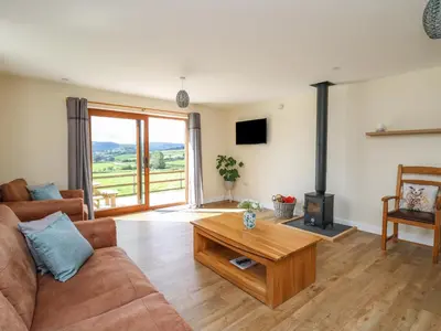 a living room with a couch and a wood stove at Awel y Bryn in Rhayader