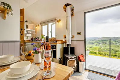 a kitchen with a table with plates and wine glasses at 1 Bed in Llangadfan oc-c27292 in Llangadfan