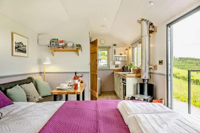 a bedroom with a large bed and a kitchen at 1 Bed in Llangadfan oc-c27292 in Llangadfan