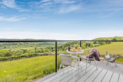a patio with a table and chairs on a deck at 1 Bed in Llangadfan oc-c27292 in Llangadfan