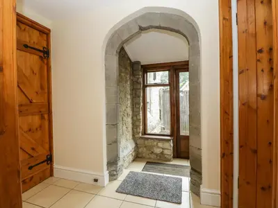 an archway in a hallway with a door at Keepers Cottage in Leominster