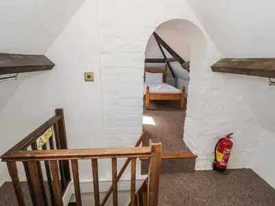 a room with a staircase and a room with a bed at Stables Cottage in Leominster