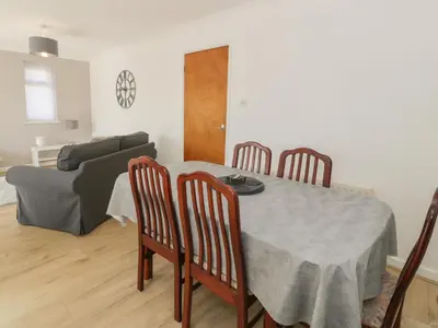 a dining room with a table and chairs and a couch at Trem Y Foel in Penrhyndeudreath