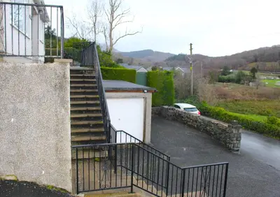 a stairway leading to a garage with a white garage door at Trem Y Foel in Penrhyndeudreath