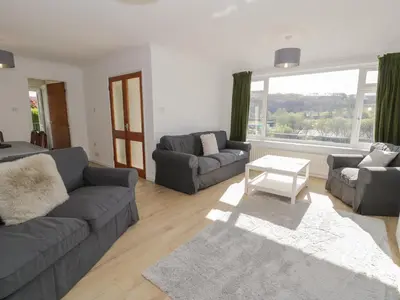 a living room with two couches and a table at Trem Y Foel in Penrhyndeudreath