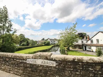 a river arrow sign on a stone wall in a village at Foxglove in Leominster