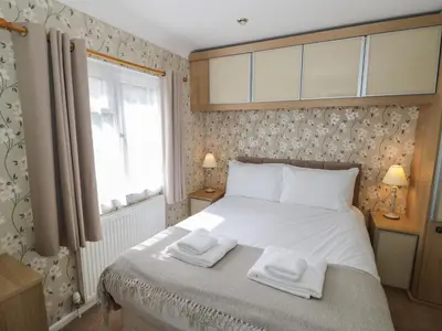 a bedroom with a bed with two towels on it at Foxglove in Leominster