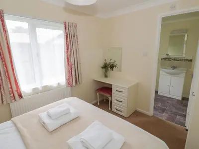 a bedroom with a bed and a sink and a window at Daffodil in Leominster