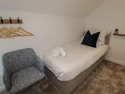 a bed and a chair in a room at Rhos Las in Derwen