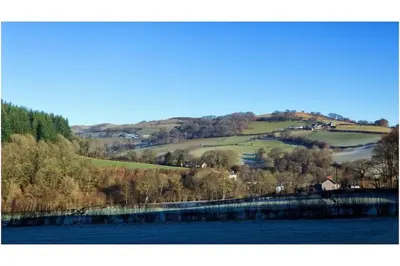 a view of a valley with a river and trees at River Cottage Brecon: Hot Tub, Fire, Balcony, Wifi in Brecon