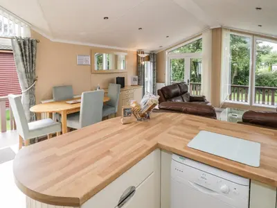 a kitchen and living room with a wooden counter top at Daisy in Leominster
