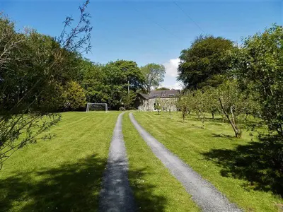 a dirt road in the middle of a grass field at Converted Granary on a rural small holding in Cross Inn