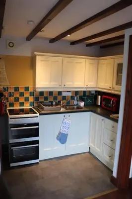 a kitchen with white cabinets and a stove top oven at Garn Lodge in Newtown