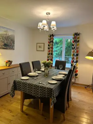 a dining room table with chairs and a tablecloth on it at Erw Fair in Arthog