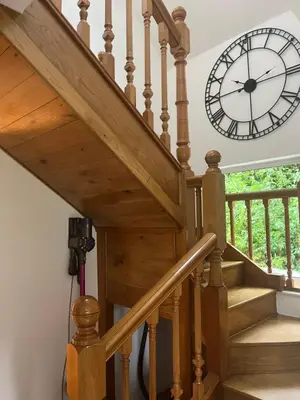 a clock on the wall next to a staircase at Erw Fair in Arthog