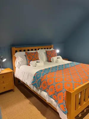 a bedroom with a bed with two pillows on it at Erw Fair in Arthog