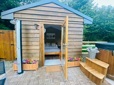 a wooden out house with a bed in it at The Haystack in Oswestry