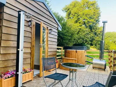 a backyard patio with a grill and a table and chairs at The Haystack in Oswestry
