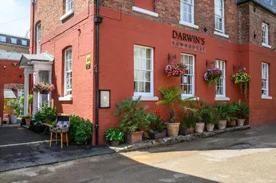 a red brick building with potted plants on it at Darwins Townhouse in Shrewsbury