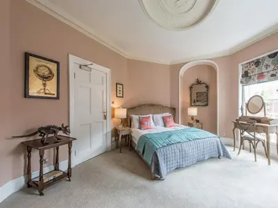 a bedroom with a bed and a table and a window at Darwins Townhouse in Shrewsbury