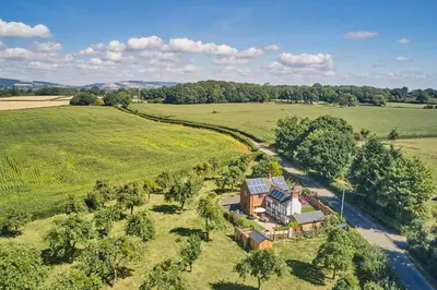 an aerial view of a house in the middle of a field at Powk Meadow Farmhouse in Leominster