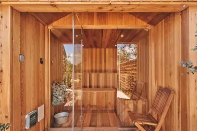 a wooden sauna with a wooden bench and a chair at Powk Meadow Farmhouse in Leominster