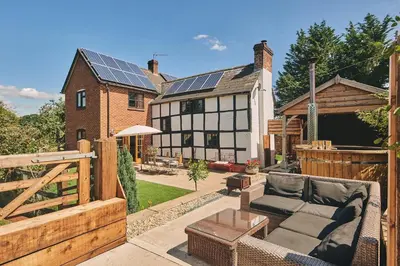 a backyard with a house with solar panels on it at Powk Meadow Farmhouse in Leominster