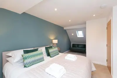 a bedroom with a large white bed with green pillows at The Lawley in Shrewsbury