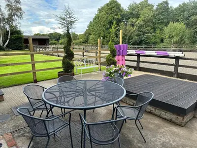 a patio with a table and chairs and a wooden deck at The Lawley in Shrewsbury