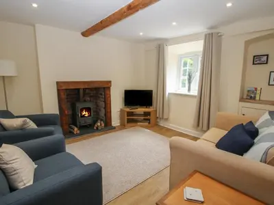 a living room with a couch and a fireplace at Bluebell's Cottage in Shrewsbury