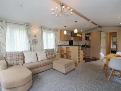 a living room with a couch and a table and a kitchen at Dove in Leominster