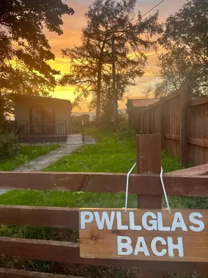 a sign on a fence with a villas beach at Pwllglas Bach - Spacious Cabin in Machynlleth
