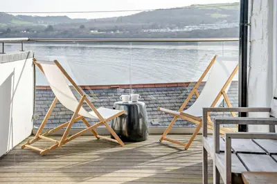 two chairs on a balcony with a view of the water at No.1 Sail House in New Quay