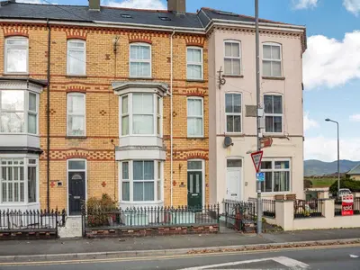 a large brick building on the corner of a street at Jack's House- Uk40741 in Tywyn