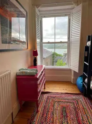 a room with a dresser in front of a window at Rhianfa 4 bedroom house minutes walk from the beach in New Quay
