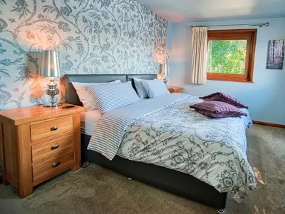 a bedroom with a bed and a night stand with a lamp at Arenig - Bala Lake in Bala