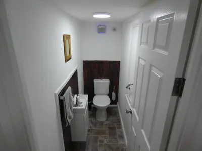 a small bathroom with a toilet and a door at 3 Oaks Lodge in Shrewsbury