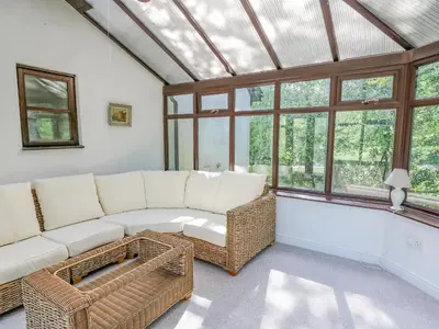 a living room with a white couch and windows at The Coach House at Plas Dolguog in Machynlleth