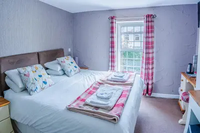 a bedroom with a bed with towels and a window at The Cock Hotel in Bronllys