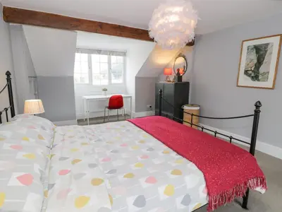 a bedroom with a bed with a red rug at Swn Yr Afon in Tywyn