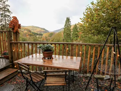 a wooden table with a potted plant on a deck at The Kites Nest in Ystrad Meurig