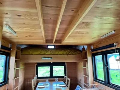 a dining room in a tiny house with wooden ceilings at Ox Box Cabin Lyonshall Kington in Hereford