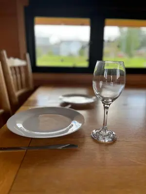 a table with a plate and a glass on it at Ox Box Cabin Lyonshall Kington in Hereford