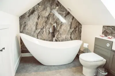 a bathroom with a white bath tub and a toilet at The Granary in Montgomery