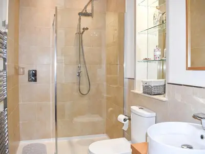 a bathroom with a shower with a toilet and a sink at Cartws Blaenparc Coach House - Uk41031 in Mydroilin